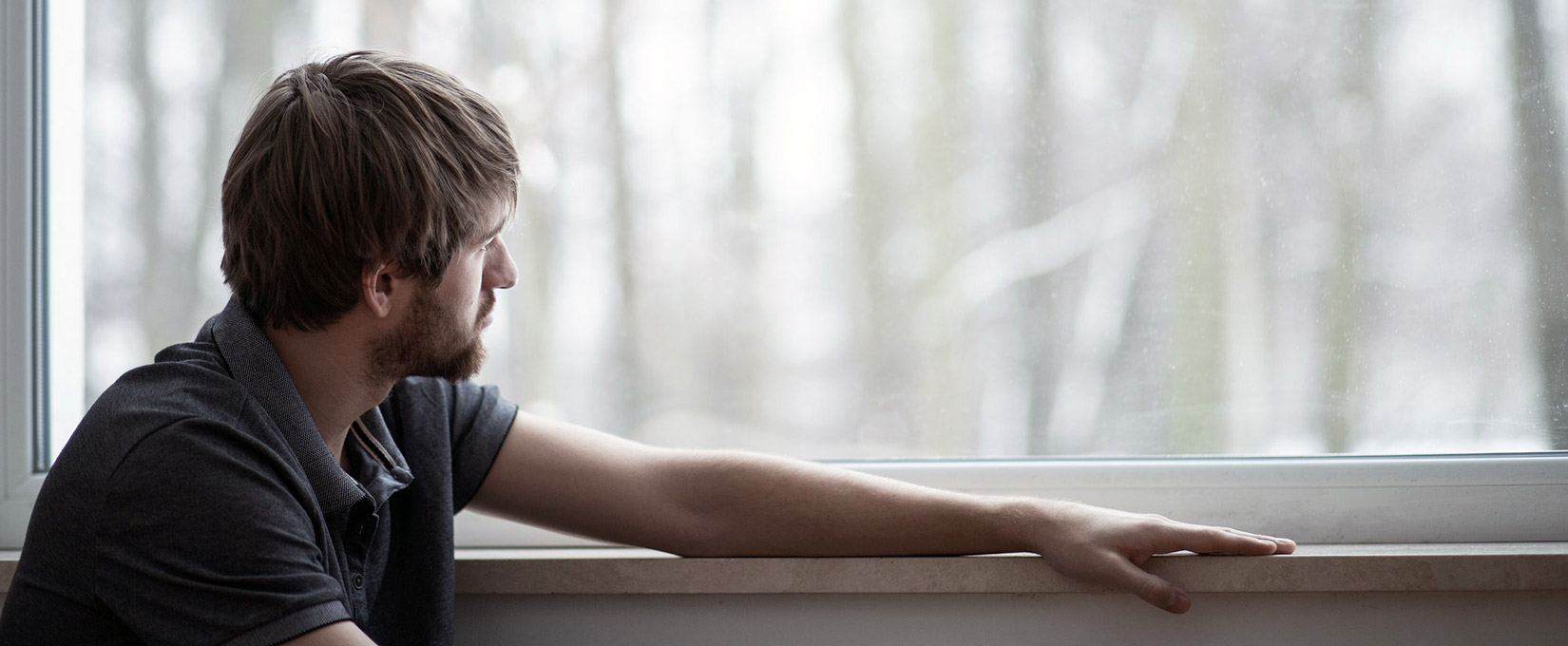 man looking out window